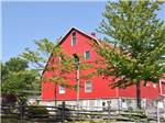 A big red barn by trees at CAMPARK RESORTS FAMILY CAMPING & RV RESORT - thumbnail