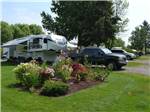 A truck and fifth wheel trailer in an RV site at JIM & MARY'S RV PARK - thumbnail