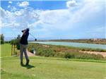 A man teeing off golfing at RIO BEND RV & GOLF RESORT - thumbnail