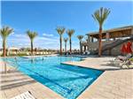 Swimming pool with palm trees and red umbrellas at VIEWPOINT RV & GOLF RESORT - thumbnail