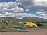 Yellow canopy and pickeball court in sprawling green landscape at ROYAL VIEW RV PARK - thumbnail