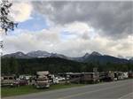 RVs parked near road as mountains loom on horizon at HAINES HITCH-UP RV PARK - thumbnail