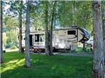 Fifth wheel and truck parked in gravel site at DOLORES RIVER RV RESORT BY RJOURNEY - thumbnail