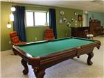 A pool table with orange colored chairs in background at ELK CREEK RV PARK - thumbnail