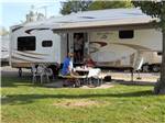 A couple eating outside of their trailer at AMERICAN RV RESORT - thumbnail