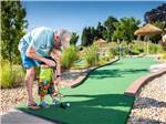 A man and small child playing mini golf at CHERRY HILL PARK - thumbnail