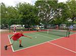Campers playing tennis at ENCORE HARBOR LAKES - thumbnail