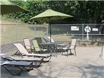 Chaise lounges and tables poolside at ST CLOUD CAMPGROUND & RV PARK - thumbnail