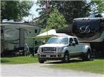 Fifth-wheel and pickup truck parked at campsite at ST CLOUD CAMPGROUND & RV PARK - thumbnail