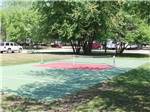Pickleball court surrounded by lawn at ST CLOUD CAMPGROUND & RV PARK - thumbnail