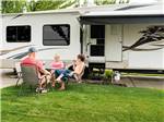 A group of people sitting outside of their RV at PHOENIX RV PARK - thumbnail
