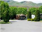 RV in site with hills in the background at COWBOY RV PARK - thumbnail