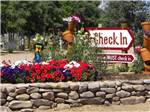 The check in sign with flowers at GRAPE CREEK RV PARK CAMPGROUND & CABINS - thumbnail