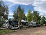 A row of motorhomes in gravel sites at GRAPE CREEK RV PARK CAMPGROUND & CABINS - thumbnail