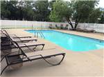 Community swimming pool with lounge chairs around it at CAHOKIA RV PARQUE - thumbnail