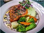 A dinner plate with cooked salmon and vegetables at RIVER'S EDGE RV PARK & CAMPGROUND - thumbnail