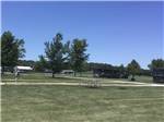 Grassy field and trees on sunny day at AMANA RV PARK & EVENT CENTER - thumbnail