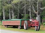 A red tractor and wagon at PAUL BUNYAN CAMPGROUND - thumbnail