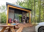 A family sitting on the porch of the cabin at CAMPING COLIBRI - thumbnail