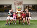 Family sitting on a bench with a Yogi Bear statue at JELLYSTONE PARK AT MAMMOTH CAVE - thumbnail