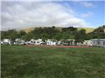 RVs in sites adjacent to large grass area at BETABEL RV PARK - thumbnail
