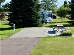 An empty paved RV site with a picnic table at ROBIDOUX RV PARK - thumbnail