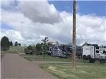 RVs parked on paved spaces with green belts in between at ROBIDOUX RV PARK - thumbnail