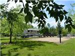 Looking at some of the gravel RV sites thru trees at SHERK'S RV PARK - thumbnail