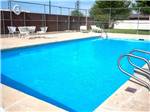 Rectangular pool with white table and chairs nearby at TOWN & COUNTRY RV PARK - thumbnail