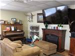 A couch and piano in one of the rooms at ROCKWELL RV PARK - thumbnail