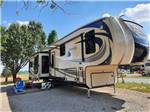 A gravel RV site with a fifth wheel trailer at DAD'S BLUEGRASS CAMPGROUND - thumbnail