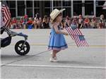 A little girl holding American flags in a parade at CODY YELLOWSTONE - thumbnail
