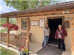 Two people standing next to the office door at BAUER'S CANYON RANCH RV PARK - thumbnail