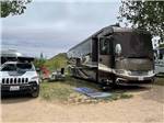 A motorhome in a gravel RV site at BAUER'S CANYON RANCH RV PARK - thumbnail