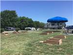 Horseshoe pits on grass in foreground near RVs at OWL CREEK MARKET + RV PARK - thumbnail