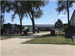 Paved RV sites with picnic tables and shade at OWL CREEK MARKET + RV PARK - thumbnail