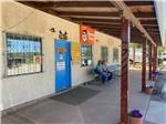 A couple sitting in front of the office at BLUE SPRUCE RV PARK - thumbnail