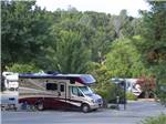 RVs parked in sites with lush vegetation at ANGELS CAMP RV RESORT - thumbnail