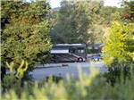 View through the trees of a motorhome at ANGELS CAMP RV RESORT - thumbnail