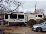 Fifth wheel parked at RV site at OUTDOOR LIVING CENTER RV PARK - thumbnail