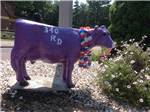 A cow statue next to some flowers at WAYNESBORO NORTH 340 CAMPGROUND - thumbnail