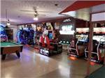 Arcade games and a pool table in the rec room at LAKE RIDGE RV RESORT - thumbnail