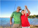 A father and son holding a fish at LOYD PARK CAMPING CABINS & LODGE - thumbnail