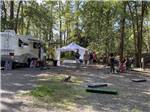 A group of people playing a game next to a motorhome at WHISPERING PINES RV CAMPGROUND - thumbnail