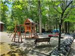 The playground set and cornhole boards at SMOKY BEAR CAMPGROUND AND RV PARK - thumbnail