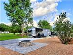 An Airstream in a paved RV site with a fire pit at BIG MEADOW FAMILY CAMPGROUND - thumbnail