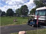 A golf cart parked in front of a motorhome at GRAND HINCKLEY RV RESORT - thumbnail