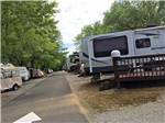 A row of RVs among some trees at OUTBACK RV RESORT - thumbnail