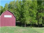 Barn-shaped red building with tree in background at ELK MEADOW LODGE AND RV RESORT - thumbnail
