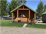 A wooden cabin with a swing on the deck at YELLOWSTONE GRIZZLY RV PARK - thumbnail